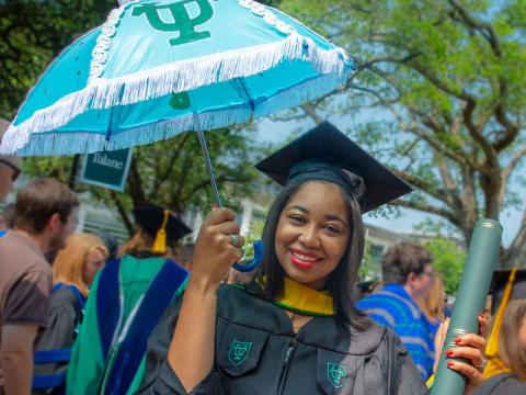 Graduate celebrates with umbrella after Commencement