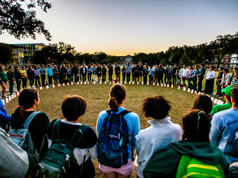 Students stand in circle and hold vigil on campus
