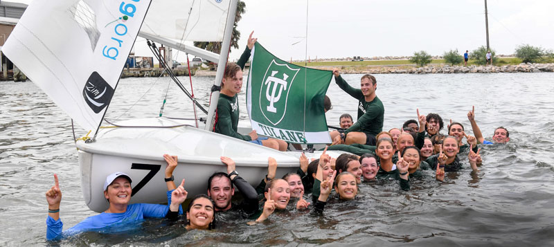 Sailing team celebrates in the water after competing