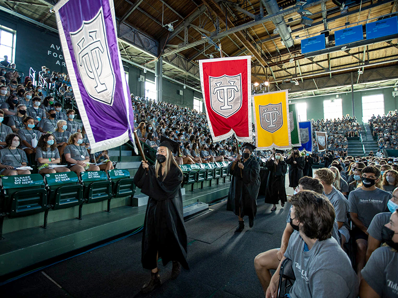 Students process into the arena with banners during Convocation