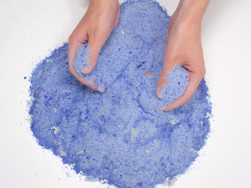 Recycled blue glass held in palm of hand