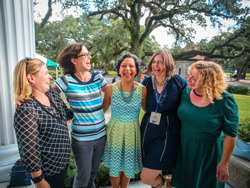 A group of friends shares a laugh at Homecoming