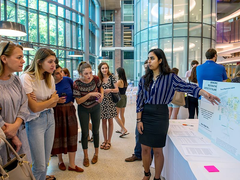 Ishanya Narang, right, discusses ways to create justice for survivors of sexual assault during a poster session.
