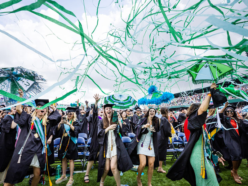 Graduates celebrate with streamers at Yulman Stadium