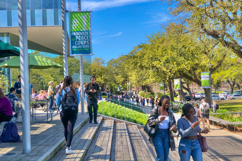 Students walking across the uptown campus on a sunny day