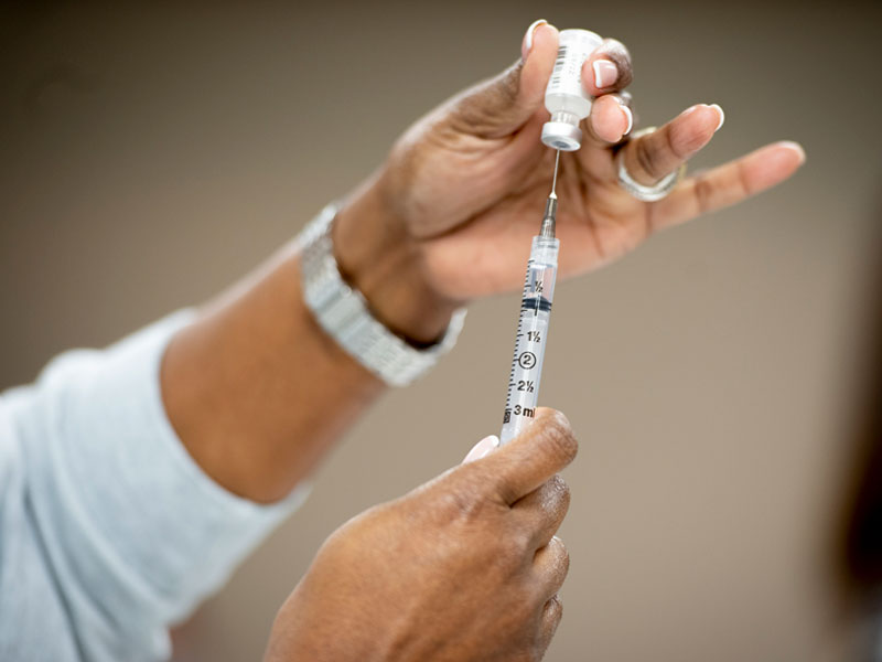 Health professional prepares vaccine for administration